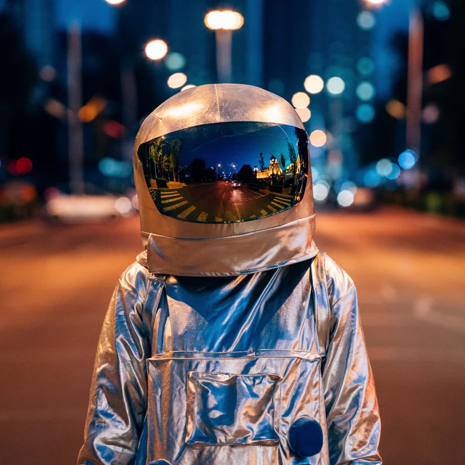 Spaceman on a street in a city at night